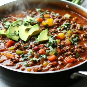 To make a great Whole30 Paleo chili, you need a few key ingredients: - 1 lb ground beef or ground turkey - 1 medium onion, finely diced - 3 cloves garlic, minced - 1 bell pepper, diced - 1 can (14 oz) diced tomatoes, with no added sugar - 1 can (14 oz) tomato sauce, no added sugar - 2 tablespoons chili powder - 2 teaspoons ground cumin - 1 teaspoon smoked paprika - 1 teaspoon dried oregano - &frac12; teaspoon salt, or to taste - &frac12; teaspoon black pepper, or to taste - 1 tablespoon olive oil - 1 cup vegetable broth, low sodium preferred These ingredients create a solid base for rich and hearty chili. The ground meat gives the chili protein, while the vegetables add texture and flavor. The spices bring warmth and depth, making each bite delicious. While the main ingredients create a tasty dish, optional items can enhance your chili: - 1 can (15 oz) kidney beans or black beans (optional for strict Whole30) - Sliced green onions - Avocado slices - Chopped cilantro Beans add fiber and protein. Green onions, avocado, and cilantro provide fresh flavors and healthy fats. They can make your chili more filling and vibrant. If you have dietary needs, you can swap some ingredients: - Use leaner ground turkey for a lighter option. - Substitute diced tomatoes with fresh tomatoes for a homemade taste. - Replace vegetable broth with homemade chicken broth if desired. These swaps keep the chili healthy while catering to your taste. Always check labels for added sugars if you're on Whole30. Enjoy experimenting with flavors while sticking to your dietary goals! {{ingredient_image_2}} To make Whole30 Paleo Chili, start with a large pot. Heat olive oil over medium heat. When the oil shines, add diced onion and bell pepper. Saut&eacute; these for about 5 minutes. You want the onion to look soft and clear. Then, add minced garlic and cook for 1-2 minutes. Stir it often until the garlic smells good and turns a light gold. Next, add ground beef or turkey. Use a spatula to break the meat into small pieces. Cook for 6-8 minutes, stirring now and then. The meat should turn brown and be fully cooked. After that, sprinkle in chili powder, cumin, smoked paprika, oregano, salt, and pepper. Mix it all well so the meat gets covered in spices. Now, pour in diced tomatoes, tomato sauce, and vegetable broth. Stir everything together. Turn up the heat until it simmers gently. If you want to add beans, do it now. If you are strict with Whole30, use extra chopped veggies instead. Lower the heat and let the chili simmer for 30-40 minutes. Stir sometimes as it cooks. This helps it thicken to your liking. Before serving, taste the chili. Adjust the seasoning by adding more salt or spices if needed. Serve hot, and top with green onions, avocado, or cilantro for a fresh touch. When cooking ground meat, choose a heavy pot. It helps heat evenly. Always break the meat apart with a spatula while it cooks. This ensures it cooks well. You can also let the meat brown a bit before stirring. This adds flavor. If using turkey, keep an eye on the heat. Turkey can dry out fast. To keep it moist, add a splash of broth or water during cooking. This makes the meat juicy and tasty. Cooking time affects the chili's texture. If you want a thicker chili, let it simmer longer. Stir it often to prevent sticking. If you like a thinner chili, add more broth. You can adjust cooking time based on your taste. For a softer texture, you can cook it longer. This helps the flavors blend well. Just remember to check the pot now and then. It is important to stir to keep it from burning. To make your Whole30 Paleo Chili truly shine, focus on layering flavors. Start by saut&eacute;ing the onion and bell pepper until soft. This step builds a sweet base. Next, add garlic right before the meat. This gives a great aroma. Use quality spices like chili powder and cumin. Toast them in the pot for a minute or two. This brings out their true essence. Chili is a great meal for busy weeks. You can make it ahead of time. Prepare a big batch and store it in the fridge. It keeps well for up to five days. For longer storage, freeze individual portions. This way, you can grab a meal anytime. Just reheat and enjoy. You can even add fresh toppings after reheating. This recipe makes six servings. To keep portions in check, use a measuring cup. Fill it with chili to make sure you don&rsquo;t overeat. Pair your chili with a side salad to fill your plate. This adds more veggies and keeps your meal balanced. Enjoy your chili hot and topped with your favorite fresh ingredients. Pro Tips Choose the Right Meat: Opt for grass-fed ground beef or organic turkey for better flavor and healthier fats. Spice It Up: Adjust the spice levels by adding jalape&ntilde;os or cayenne pepper if you prefer a spicier chili. Incorporate Extra Veggies: For added nutrition, include chopped zucchini or carrots when saut&eacute;ing the vegetables. Let It Rest: Allow the chili to sit for a few minutes after cooking; this helps the flavors meld together beautifully. {{image_4}} You can easily make a vegetarian version of this chili. Simply swap the meat for extra veggies. Use mushrooms, zucchini, or cauliflower for a hearty texture. You can also add lentils or chickpeas for protein. Just be sure to rinse and drain the beans if you use them. This keeps the dish Whole30 compliant. Want more flavor? You can boost the taste with fresh herbs. Cilantro or parsley add freshness. If you love heat, try adding jalape&ntilde;os or cayenne pepper. Adjust the spice level to your liking. Start with a little and taste as you go. This way, you can find the perfect balance for your chili. Toppings can change your chili game. Try sliced green onions or avocado for creaminess. Fresh cilantro adds a nice pop of color and taste. You can also use dairy-free cheese or a squeeze of lime. These toppings not only look great but also enhance the flavor. Feel free to mix and match to find your perfect combo! After you make your Whole30 Paleo Chili, let it cool. Once cooled, transfer it to an airtight container. This helps keep it fresh. Store it in the fridge for up to five days. Make sure it&rsquo;s sealed tight to prevent any odors from the fridge from affecting the chili. When you're ready to enjoy your chili again, reheat it on the stove. Pour the chili into a saucepan over medium heat. Stir it often to heat evenly. If the chili seems thick, add a little vegetable broth or water. This will bring back its original texture and flavor. You can also use the microwave. Place it in a bowl and cover it with a lid. Heat it in short bursts, stopping to stir. Freezing is a great way to save your chili for later. First, cool the chili completely. Then, use freezer-safe containers or bags. Divide it into portions for easy meals later. When you want to eat it, thaw it in the fridge overnight. Reheat it on the stove or microwave as mentioned before. This chili can last up to three months in the freezer, making it a perfect meal prep option. Yes, Whole30 Paleo Chili is compliant with Whole30 diets. It uses whole ingredients without added sugar or grains. The recipe features ground beef or turkey, fresh vegetables, and spices. Ensure your canned goods, like tomatoes and broth, don't have added sugars. This chili supports your Whole30 goals while being tasty and filling. Absolutely! You can easily make chili in a slow cooker or Instant Pot. For a slow cooker, brown the meat and veggies first. Then, add everything to the slow cooker and cook on low for 6-8 hours. For an Instant Pot, use the saut&eacute; setting to brown the meat and veggies. Then, add other ingredients, seal the lid, and cook on high pressure for about 15 minutes. Both methods save time and enhance flavor. To keep your chili sugar-free, read labels carefully. Use diced tomatoes and tomato sauce with no added sugar. Choose vegetable broth that is low sodium and sugar-free. If using beans, rinse them well to remove any added sugars. By selecting the right ingredients, your chili will stay true to Whole30 rules. This blog post covered everything you need for Whole30 Paleo Chili. We explored key ingredients and optional choices that boost flavor and health. I shared step-by-step cooking tips to get the best texture and taste. You learned about variations for vegetarians and flavor tweaks. I also offered storage tips to keep your chili fresh. In summary, you can enjoy making delicious chili while sticking to your diet. Happy cooking!