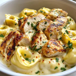 - 12 ounces cheese tortellini (fresh or frozen) - 2 boneless, skinless chicken breasts - 1 cup heavy cream - 3 tablespoons extra virgin olive oil - 4 cloves garlic, finely minced - 1 cup freshly grated Parmesan cheese - 1 teaspoon Italian seasoning - Fresh parsley, chopped, for garnish - Red pepper flakes - Salt and black pepper To make Garlic Parmesan Tortellini with Chicken, gather all the ingredients. It's important to have fresh cheese tortellini for the best taste. You can use frozen tortellini if that’s what you have. For the chicken, boneless, skinless breasts work great. They cook evenly and stay juicy. Heavy cream adds a rich flavor. It makes the sauce creamy and smooth. You will also need some olive oil to cook the chicken and garlic. Garlic is key for flavor and aroma. Parmesan cheese brings a salty taste that pairs perfectly with the cream. Italian seasoning adds a nice herbal note. Lastly, fresh parsley makes a lovely garnish. It adds color and freshness. If you like a bit of heat, red pepper flakes are a fun addition. Adjust salt and black pepper to your taste. With these ingredients, you can create a delightful meal that everyone will love! {{ingredient_image_2}} - Boiling Method: Fill a large pot with water. Add a good pinch of salt. Bring the water to a boil. Once boiling, add the cheese tortellini. Cook them until they float. This shows they are done. - Drain and Set Aside: Carefully drain the tortellini in a colander. Set them aside while you cook the chicken. - Seasoning the Chicken Breasts: Take the chicken breasts. Sprinkle salt, pepper, and Italian seasoning on both sides. This adds great flavor. - Cooking Time and Temperature: Heat 2 tablespoons of olive oil in a skillet over medium heat. Add the chicken. Cook for about 6-7 minutes on each side. The chicken should be golden brown and reach 165°F inside. - Sautéing Garlic: In the same skillet, add 1 tablespoon of olive oil. Once hot, add minced garlic. Sauté for about 1 minute. Stir often to avoid burning. - Mixing Cream and Parmesan: Reduce the heat to low. Pour in the heavy cream while stirring. Slowly add the grated Parmesan cheese. Stir until smooth and creamy. - Incorporating Tortellini and Chicken: Add the drained tortellini to the sauce. Toss gently to coat them well. Then fold in the sliced chicken. - Adjusting Seasoning for Flavor: Taste the dish. Add more salt, pepper, or red pepper flakes for heat if you like. - Plate Presentation: Spoon the Garlic Parmesan Chicken Tortellini onto plates or a serving dish. - Optional Garnishes: Garnish with fresh chopped parsley. For extra flair, drizzle olive oil and sprinkle more Parmesan on top. Enjoy your delicious meal! - Cooking Time Recommendations: To cook tortellini perfectly, boil them for 3-5 minutes. They are ready when they float. Keep an eye on them to avoid overcooking. - Troubleshooting Undercooked Tortellini: If your tortellini is still firm, return it to boiling water. Cook for an extra minute and check again. - Seasoning Best Practices: Use salt, pepper, and Italian seasoning on both sides of the chicken. This enhances the flavor and makes every bite tasty. - Searing Techniques for Juicy Chicken: Heat olive oil until hot. Cook chicken for 6-7 minutes on each side. This creates a golden crust while keeping the inside juicy. Always check that the chicken reaches 165°F. - Additional Flavor Boosts: For a richer taste, add a pinch of red pepper flakes or fresh herbs. These can elevate your dish and add unique flavors. - Avoiding Clumps in Cheese Sauce: To prevent clumps, add cheese slowly while stirring. Keeping the heat low helps the cheese melt smoothly into the sauce. Pro Tips Use Fresh Ingredients: Fresh garlic and good-quality Parmesan cheese will elevate the flavor of your dish significantly. Don’t Overcook the Chicken: To maintain moisture, ensure you check the internal temperature and avoid cooking beyond 165°F. Adjust Cream for Thickness: If you prefer a thicker sauce, let it simmer a bit longer to reduce, or add more Parmesan for a richer texture. Garnish for Flavor: Fresh parsley not only adds color but also enhances the overall flavor profile of the dish. {{image_4}} You can change the protein in this dish to suit your taste. - Shrimp or Salmon Alternatives: If you love seafood, try shrimp or salmon. Both cook fast and add a nice flavor. For shrimp, sauté them in the pan for about 3-4 minutes until they turn pink. For salmon, cook it for about 5-6 minutes on each side until it flakes easily. - Vegetarian Options: For a meat-free meal, use mushrooms or tofu instead. Mushrooms add rich umami, while tofu absorbs all the sauce flavors. Just sauté them until golden and add them to the dish. Adding vegetables can make the dish more colorful and healthy. - Spinach or Kale: Toss in fresh spinach or kale at the end of cooking. They wilt quickly and add great nutrition. Just stir them in for a minute until they soften. - Peas or Asparagus: Sweet peas or crunchy asparagus also work well. For peas, add them in the last few minutes of cooking. For asparagus, chop it into bite-sized pieces and cook it with the chicken. You can make this dish even more exciting with some flavor tweaks. - Spicy Variations with Chili: If you like spice, add red pepper flakes or diced fresh chili to the sauce. This gives a nice kick that balances the creamy sauce. - Zesty Lemon or Herb Additions: Brighten the dish with fresh lemon juice or zest. You can also add herbs like basil or thyme for an aromatic touch. Just sprinkle them in when mixing the sauce for a fresh twist. To store leftovers, let the dish cool first. Place it in an airtight container. It keeps well in the fridge for up to three days. Always reheat gently to keep the flavors fresh. For best practices, cover the dish tightly. This helps prevent the pasta from drying out. Stir before serving to mix in any separated sauce. If you want to freeze prepped ingredients, cook the tortellini and chicken first. Let them cool completely. Then, pack them into freezer-safe bags or containers. This way, you can enjoy the dish later. For thawing and reheating, move the frozen meal to the fridge overnight. Reheat in a skillet on low heat. Add a splash of cream to loosen the sauce. In the fridge, Garlic Parmesan Tortellini with Chicken lasts about three days. In the freezer, it can stay fresh for up to three months. Signs of spoilage include an off smell and a change in color. If you see mold or if it feels slimy, it's best to discard it. Yes, you can use frozen tortellini. Just follow these steps: - Boil the water with salt. - Add the frozen tortellini directly to the boiling water. - Cook for an extra minute or two. They might take longer than fresh ones. - Once they float, they are done. Using frozen tortellini saves time. It also keeps well in your freezer for a quick meal. If you need a substitute for heavy cream, try these options: - Half-and-half works well for a lighter sauce. - Full-fat coconut milk gives a creamy texture and is dairy-free. - Greek yogurt can add richness with less fat, but mix it in off the heat. These substitutes keep the dish creamy and delicious, even if you're avoiding heavy cream. To make this recipe gluten-free, use gluten-free tortellini. Many brands offer options made from rice, corn, or quinoa. Here are some tips: - Check the package for cooking times. They may differ from regular tortellini. - Ensure that all your other ingredients, like the chicken and spices, are gluten-free. This way, you enjoy the same great flavors without gluten. Yes, you can prep this dish ahead of time. Here’s how: - Cook the tortellini as directed and cool them completely. - Cook the chicken and slice it. Store it in the fridge. - Keep the sauce separate until you're ready to serve. When you’re ready to eat: - Reheat the chicken and tortellini. - Warm the sauce on low heat, then combine everything. This makes for a quick and tasty meal when you're short on time! In this blog post, we explored a delicious Garlic Parmesan Tortellini with Chicken recipe. We covered key ingredients, cooking steps, and tips to perfect the dish. I highlighted ways to customize it with different proteins or veggies. You learned how to store leftovers for freshness and answers to common questions. Cooking is fun and rewarding. This recipe makes a tasty meal that is easy to modify. Enjoy creating your version of this creamy dish!